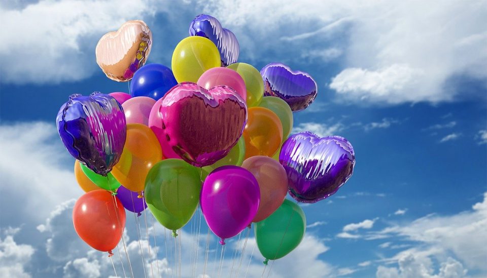 Dekorativ bild. Ballonger i olika färger mot en blå himmel med vita moln.